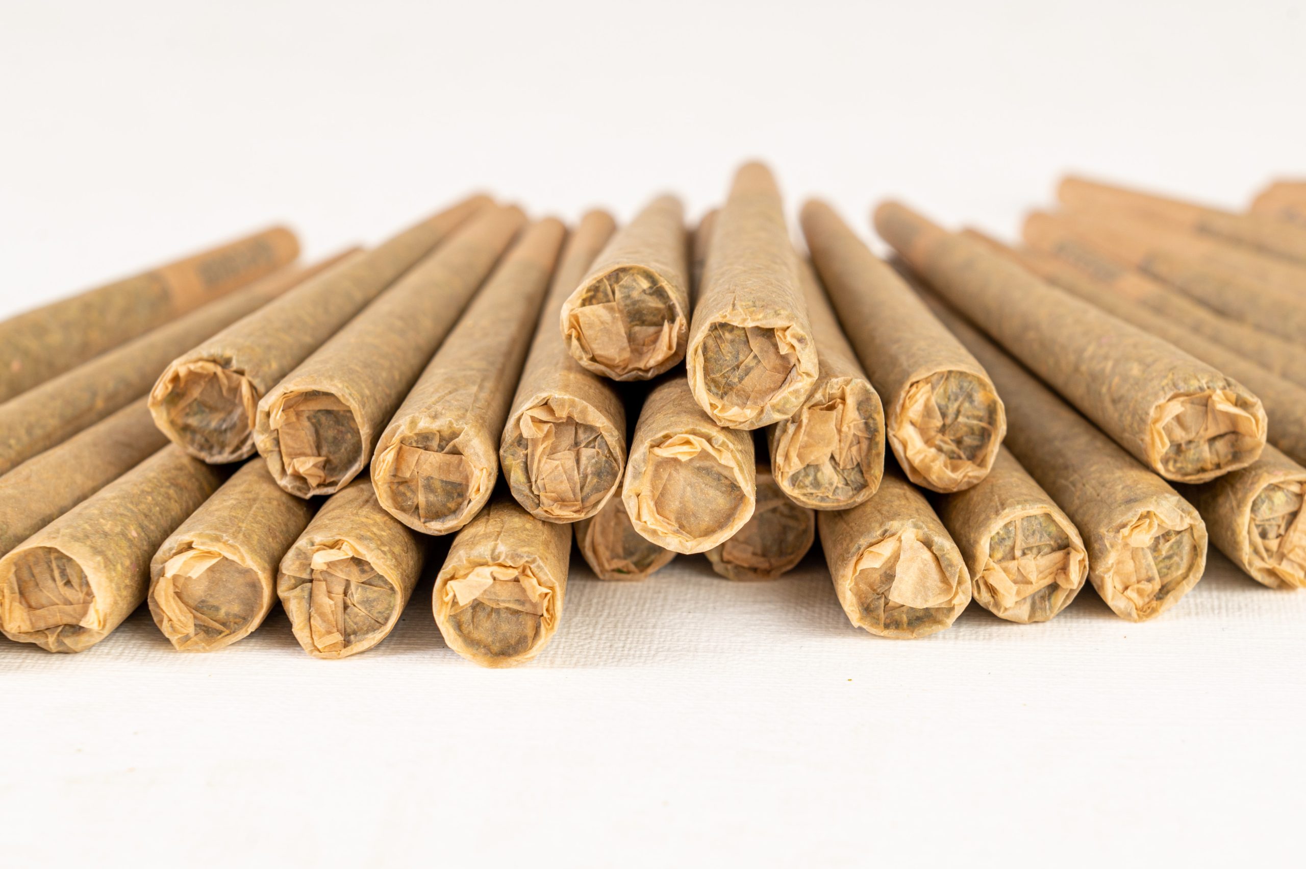 Stack of marijuana joint pre-rolled cone paper on white background, roll paper cannabis