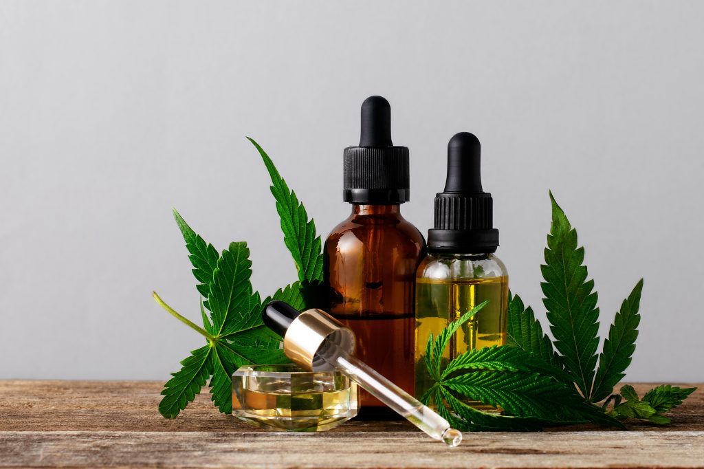 Cannabis oil in bottles on gray background with copy space.